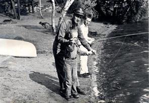 black & white image of man fishing with two boys