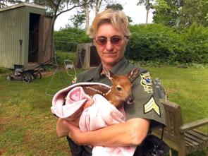officer holding a fawn wrapped in a blanket