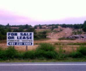 Photo of for sale or lease sign on a piece of land