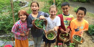 kids holding baskets with vegetables