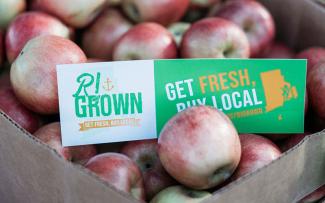 Box of red apples with RI Grown bumper sticker