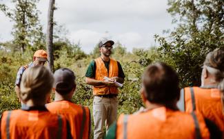 A DEM Biologists speaks to a group gathered at the Great Swamp Management Area about a recent forest health project that created new forest for small game and other native wildlife