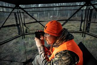 man in blind with range finder