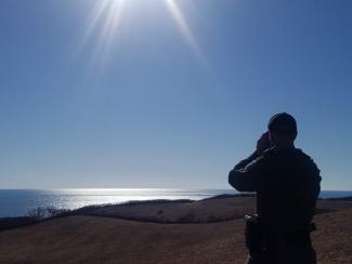 An Environmental Police Officer scans the horizon while patrolling on Block Island