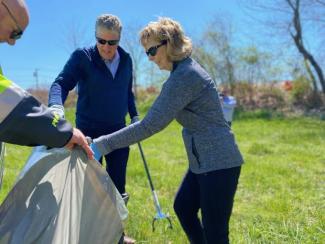 Governor Dan McKee and First Lady Susan McKee pick up litter on a sunny day