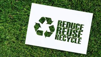 Graphic with green grass and the words Reduce, Reuse, and Recycle on it
