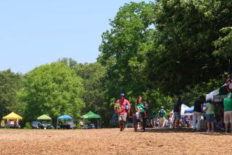 A photo shows people shopping at the RI Grown Farmers Market at Goddard Memorial State Park