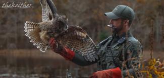 RI Environmental Police Officer holds a owl while helping to untangle it from fishing line
