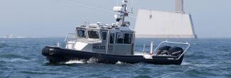 RI Environmental Police marine vessel passing the Block Island Wind Farm in the distance
