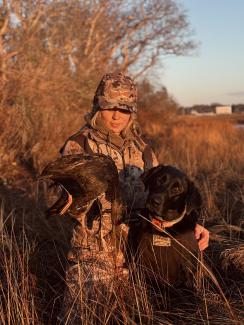 girl waterfowl hunting with dog